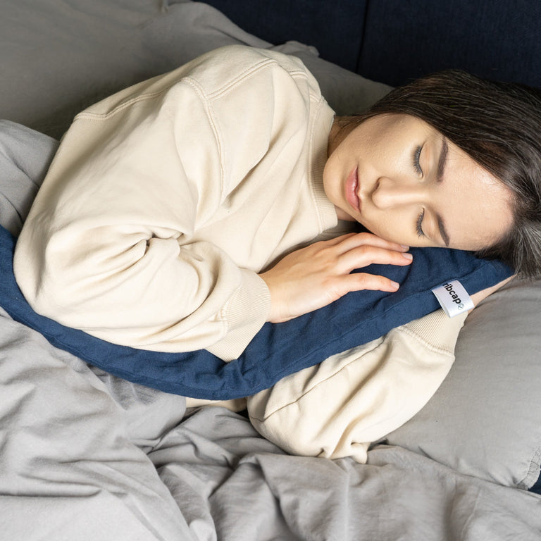 Female model sleeps with hot and cold water wrap navy blue